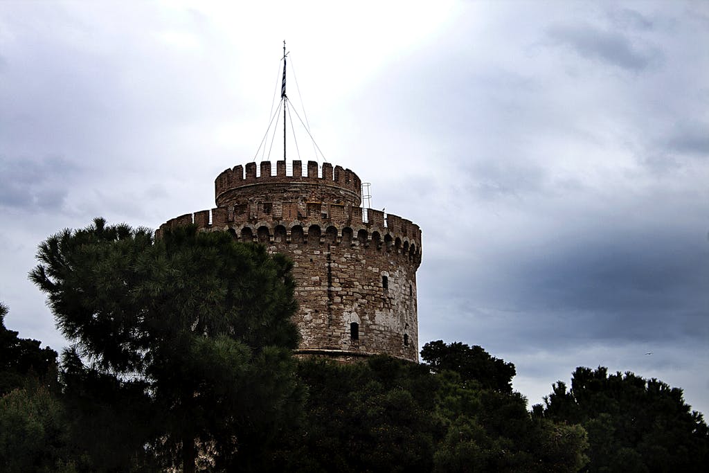À la découverte des Monuments et de la Culture de Thessalonique 4 Explore the iconic White Tower, a renowned landmark in Thessaloniki under a cloudy sky.