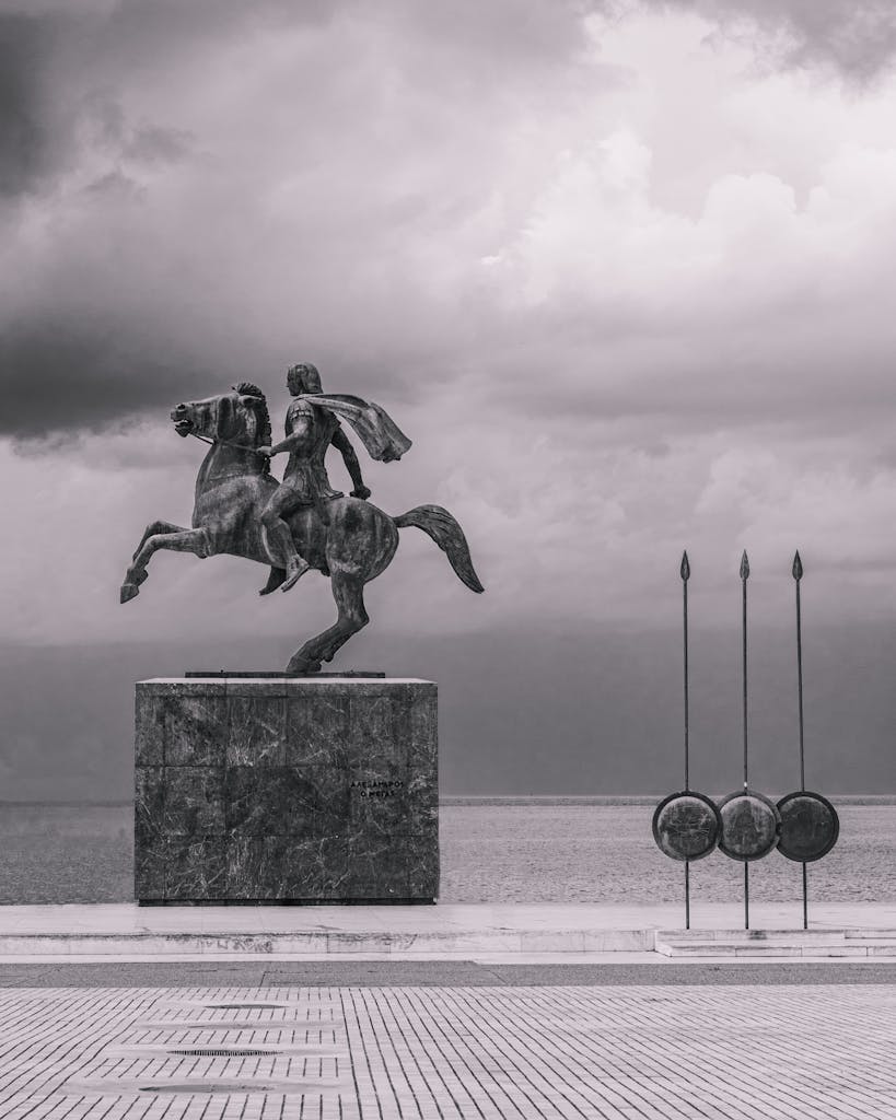 Dramatic black and white photo of Alexander the Great statue in Thessaloniki by the sea.