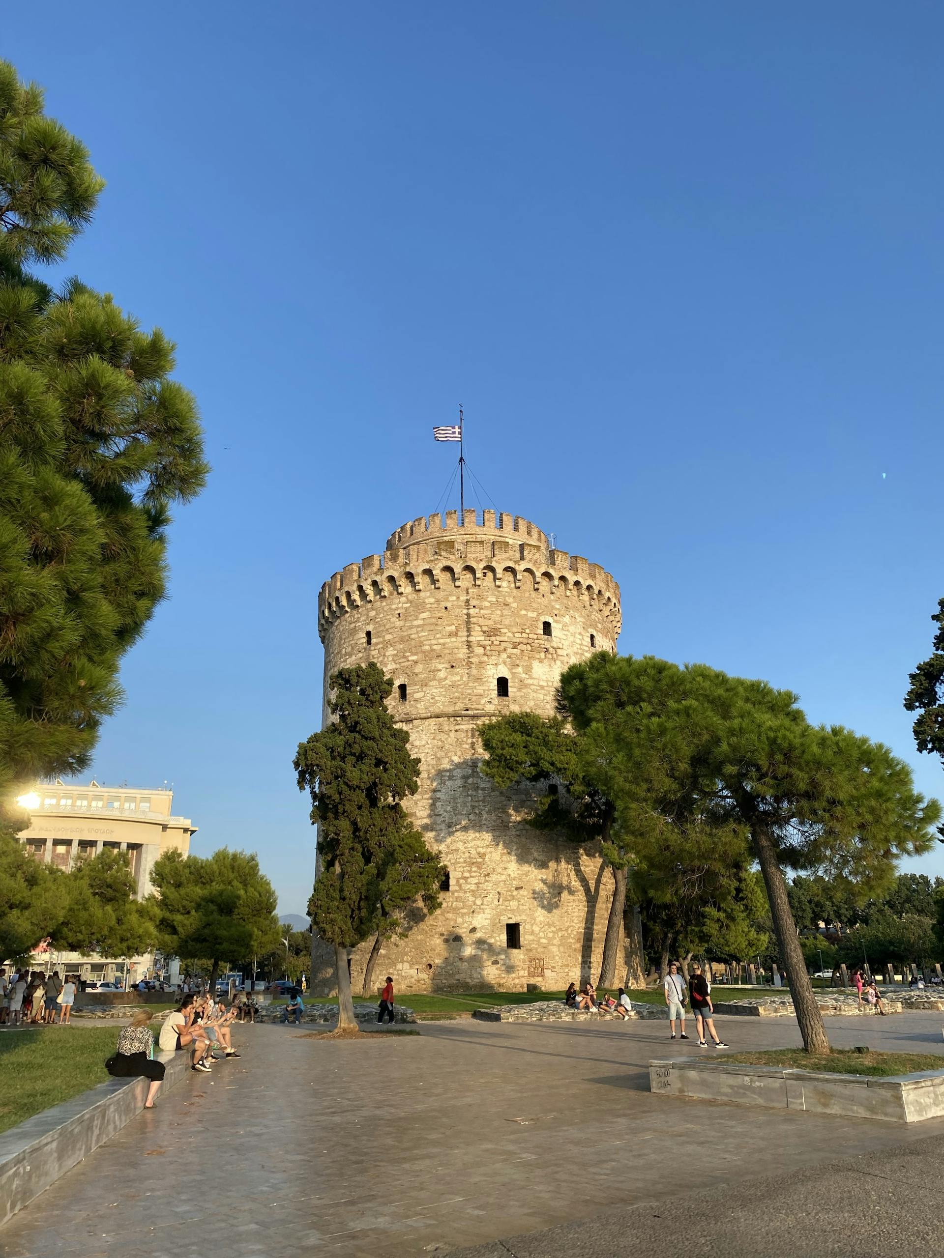 À la découverte des Monuments et de la Culture de Thessalonique 2 View of the iconic White Tower in Thessaloniki, Greece, under clear blue skies with surrounding trees.