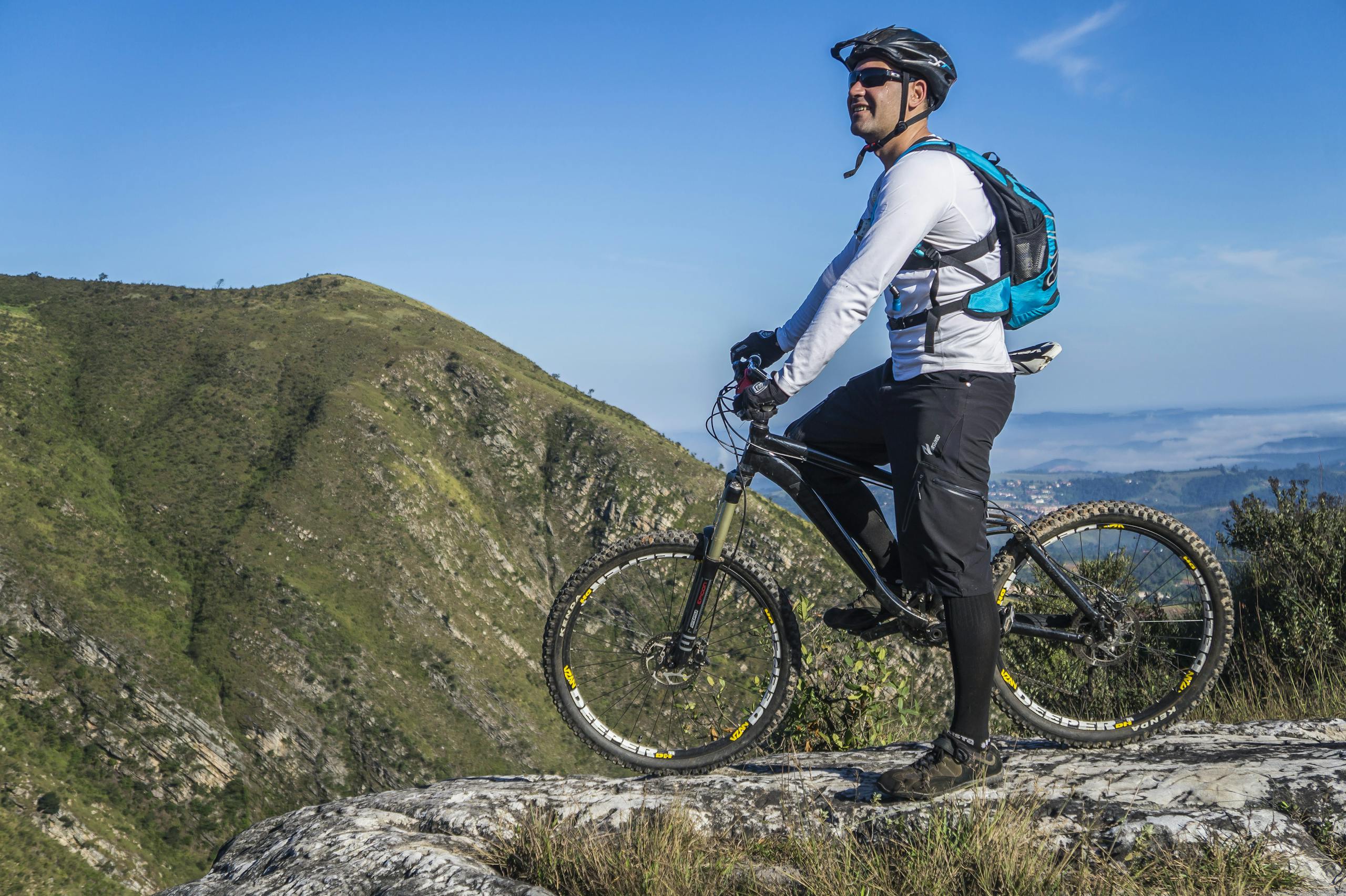 Aufregende Aktivitäten auf Chalkidiki 11 Adult cyclist on mountain bike overlooking scenic rocky landscape under clear blue sky.
